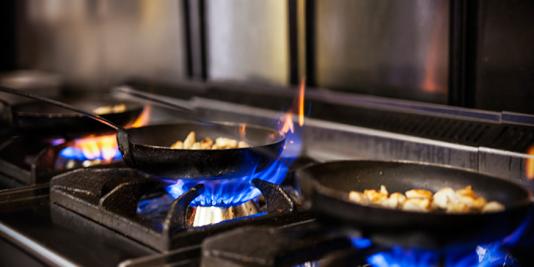 Photo of cooking pans on gas burners