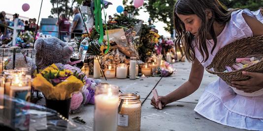 Girl lighting candle at memorial