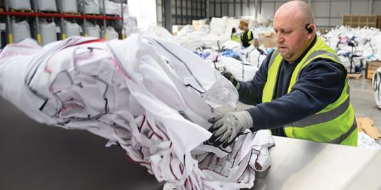 Worker sorts textiles in factory.